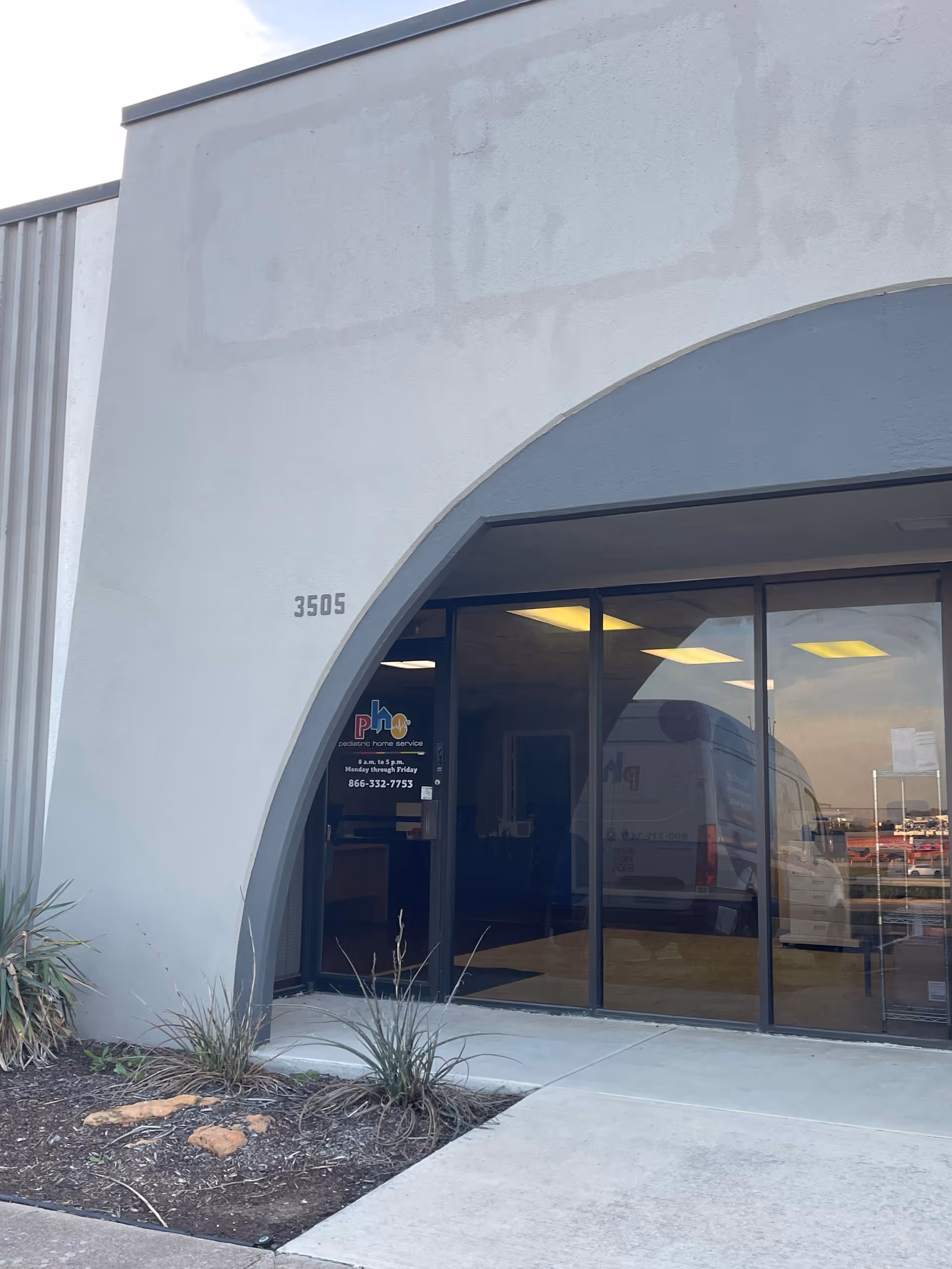 Front entrance of Pediatric Home Service building with curved arch and glass doors.