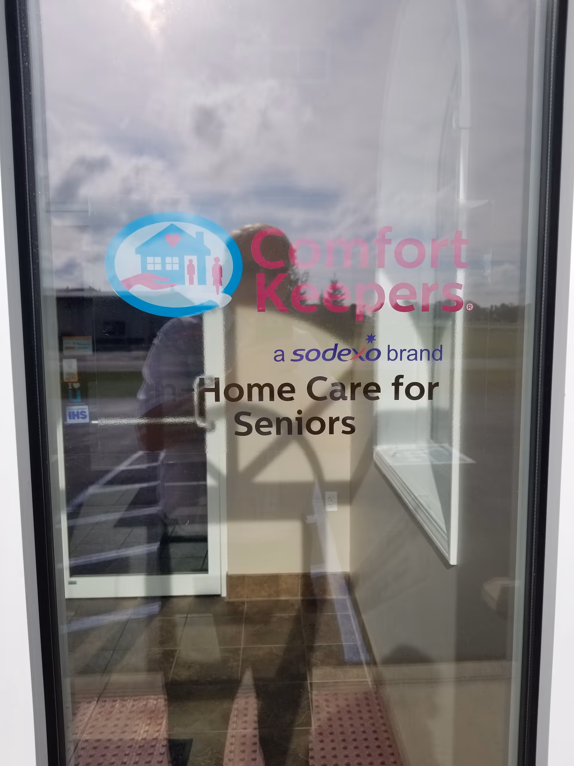 Glass entrance door displays Comfort Keepers logo and Home Care for Seniors text.