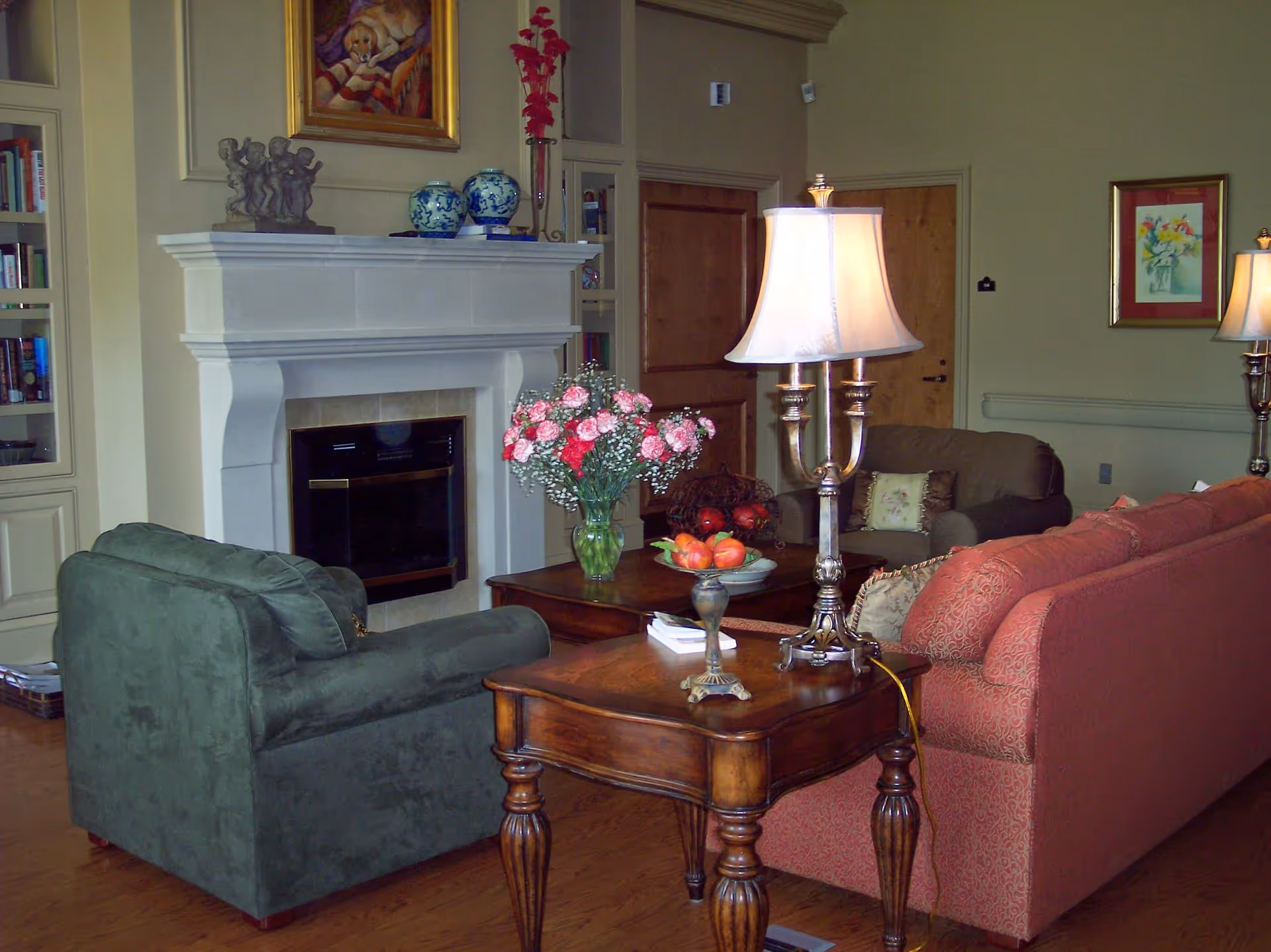 Cozy living room with green and pink sofas, a coffee table, and a fireplace.