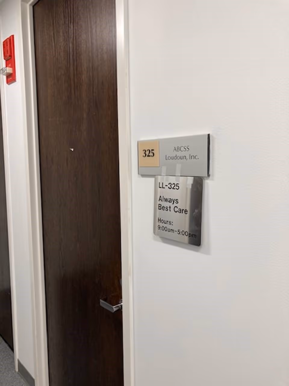 Interior hallway with a closed door and wall sign reading LL-325 Always Best Care