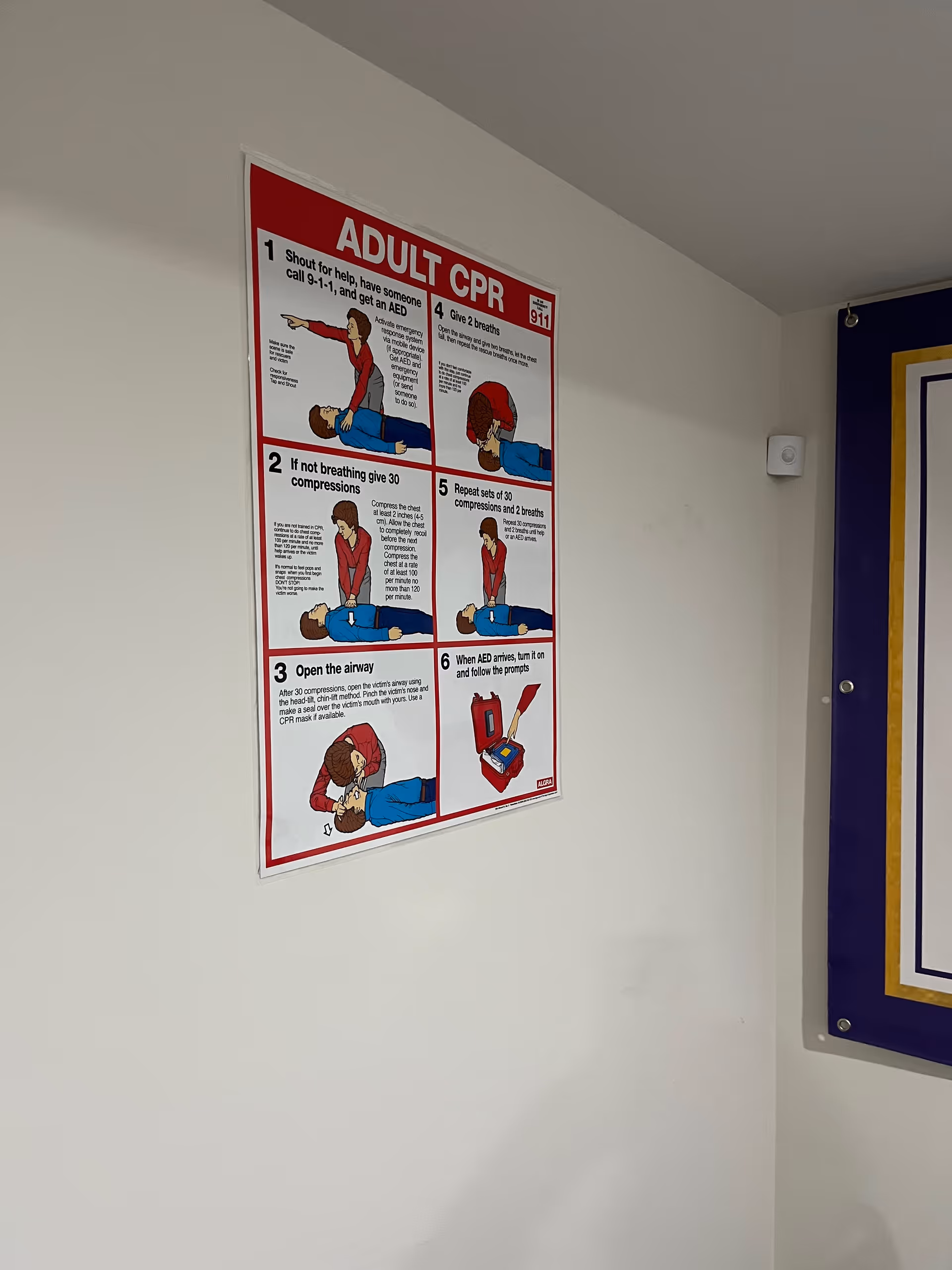 Indoor hallway featuring an adult CPR poster on the white wall.