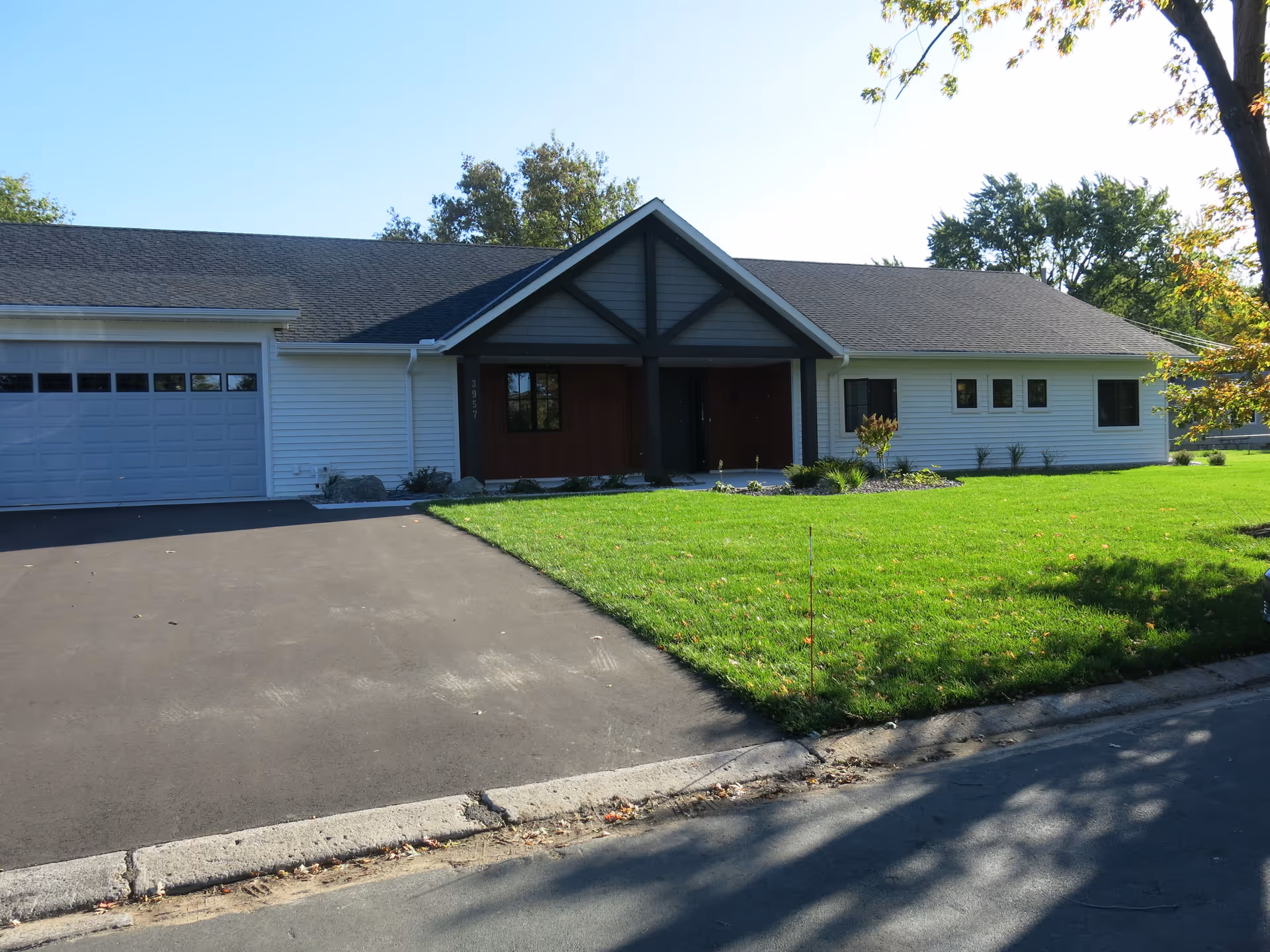 Single-story senior living facility with white siding, front entrance, and a green lawn.