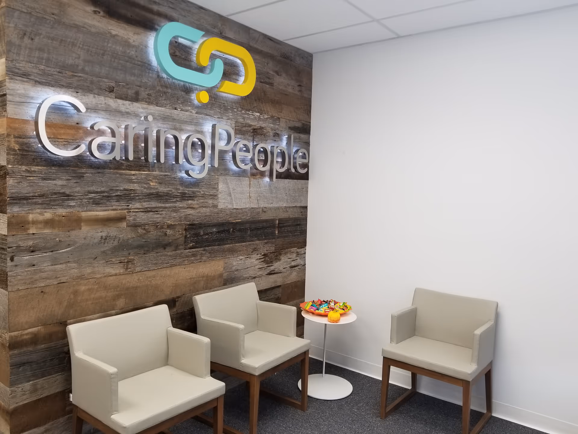Lobby seating area with wood feature wall and CaringPeople signage.