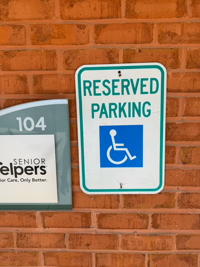 Brick exterior wall with a reserved parking sign and wheelchair icon