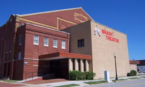 Exterior view of Brady Theater building with red brick walls and an entry canopy.