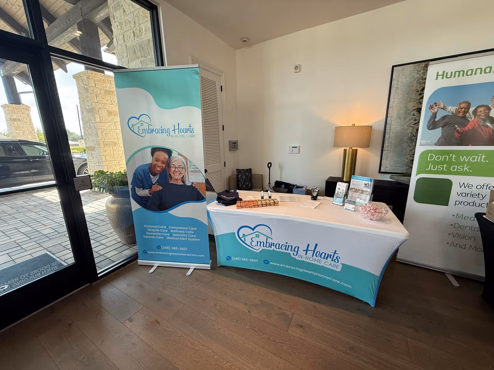 Reception desk with banners and brochures in a bright lobby of Embracing Hearts In-Home Care.