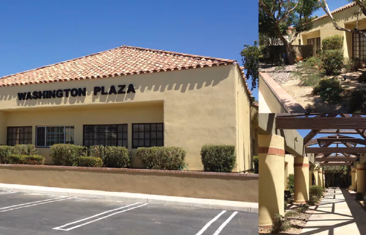 Exterior view of a beige building labeled Washington Plaza with landscaping and a walkway.