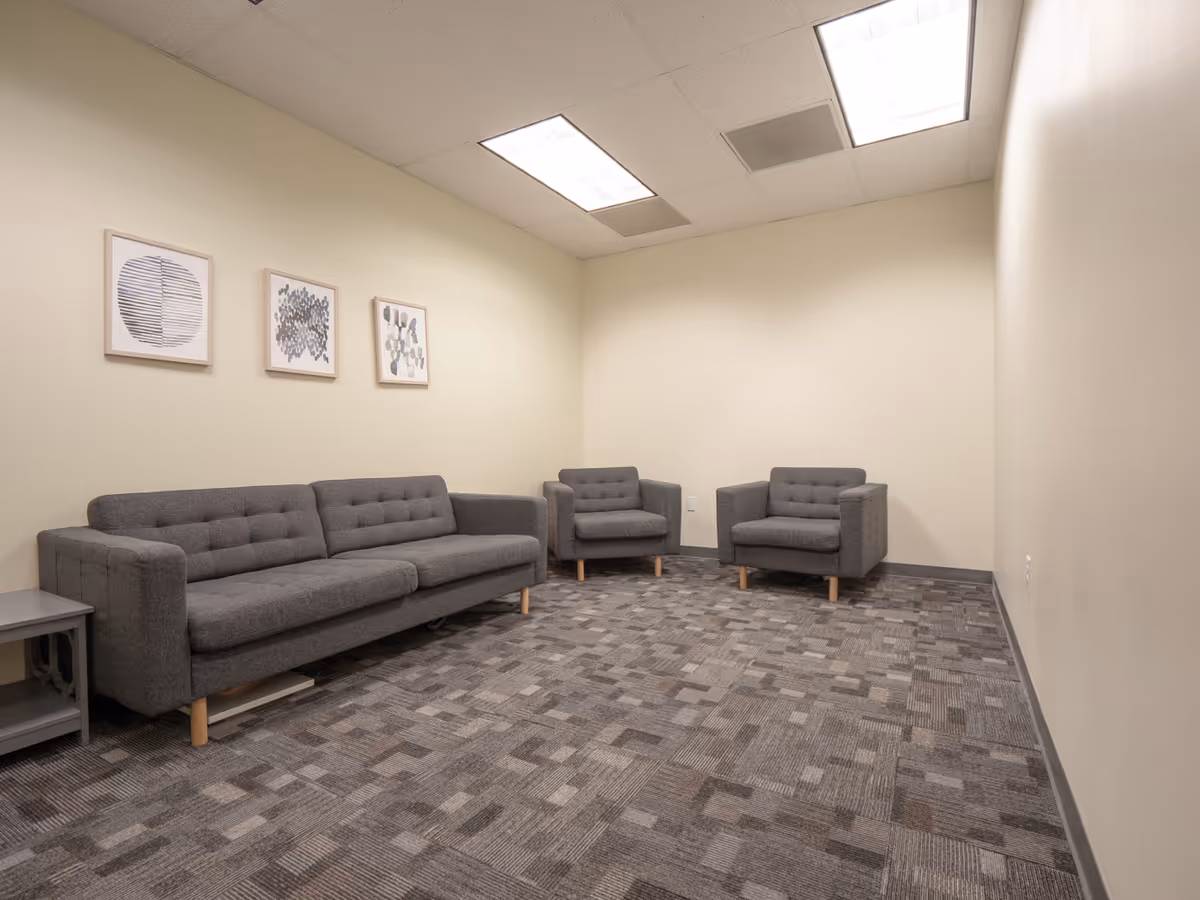 A modern lounge area with gray sofas and framed wall art.