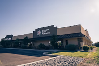Front exterior view of Nuclear Care Partners facility with parking lot and landscaping.