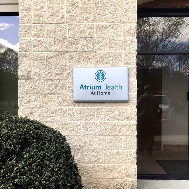 Exterior view of a brick building with an Atrium Health At Home sign.