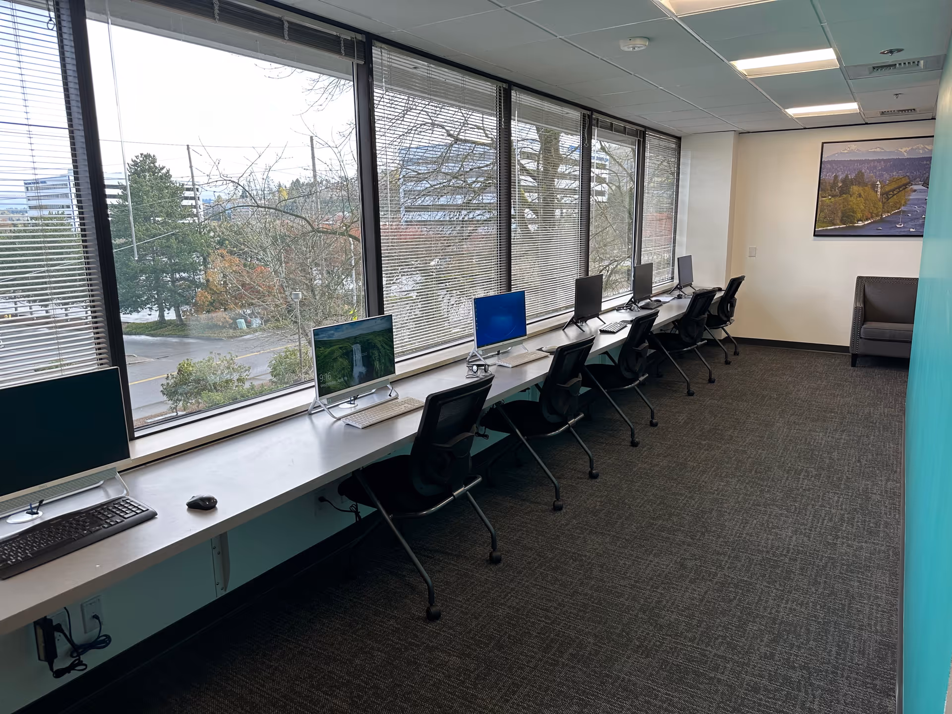 Row of computer workstations along large windows in a senior living facility.