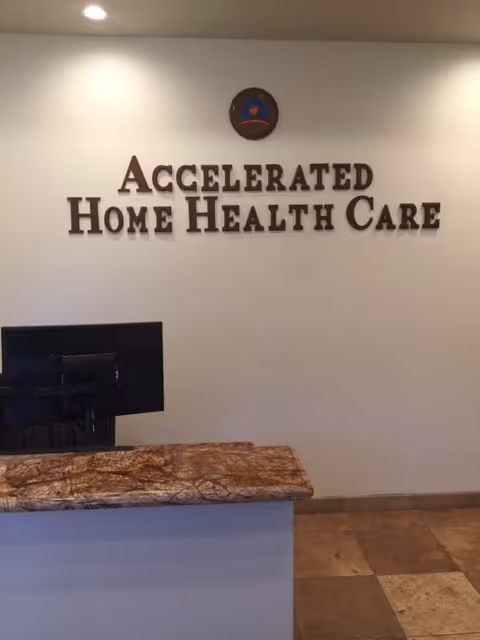 Reception desk in a lobby with a wall sign reading Accelerated Home Health Care
