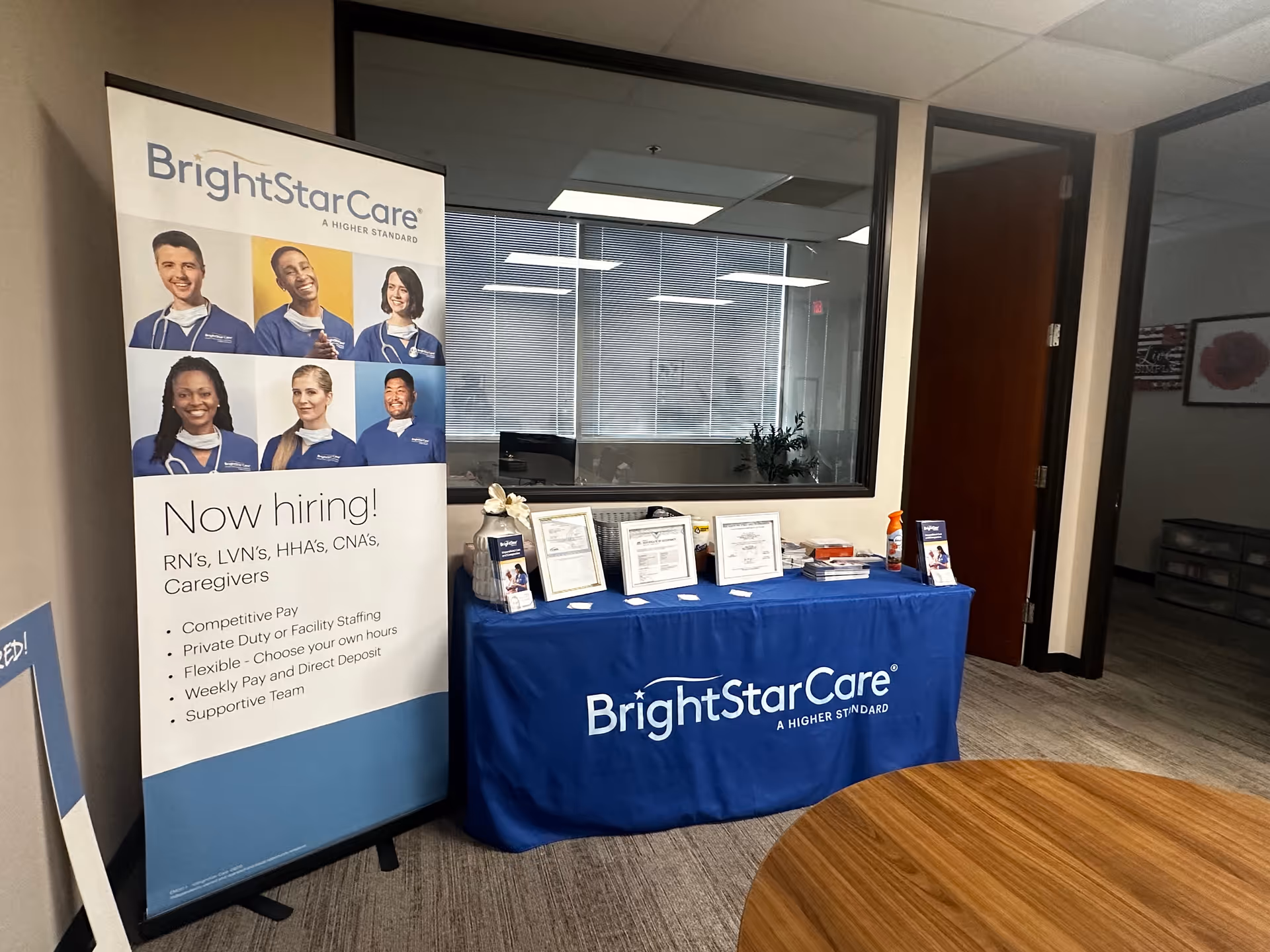 BrightStarCare recruitment banner and information table in an office hallway.