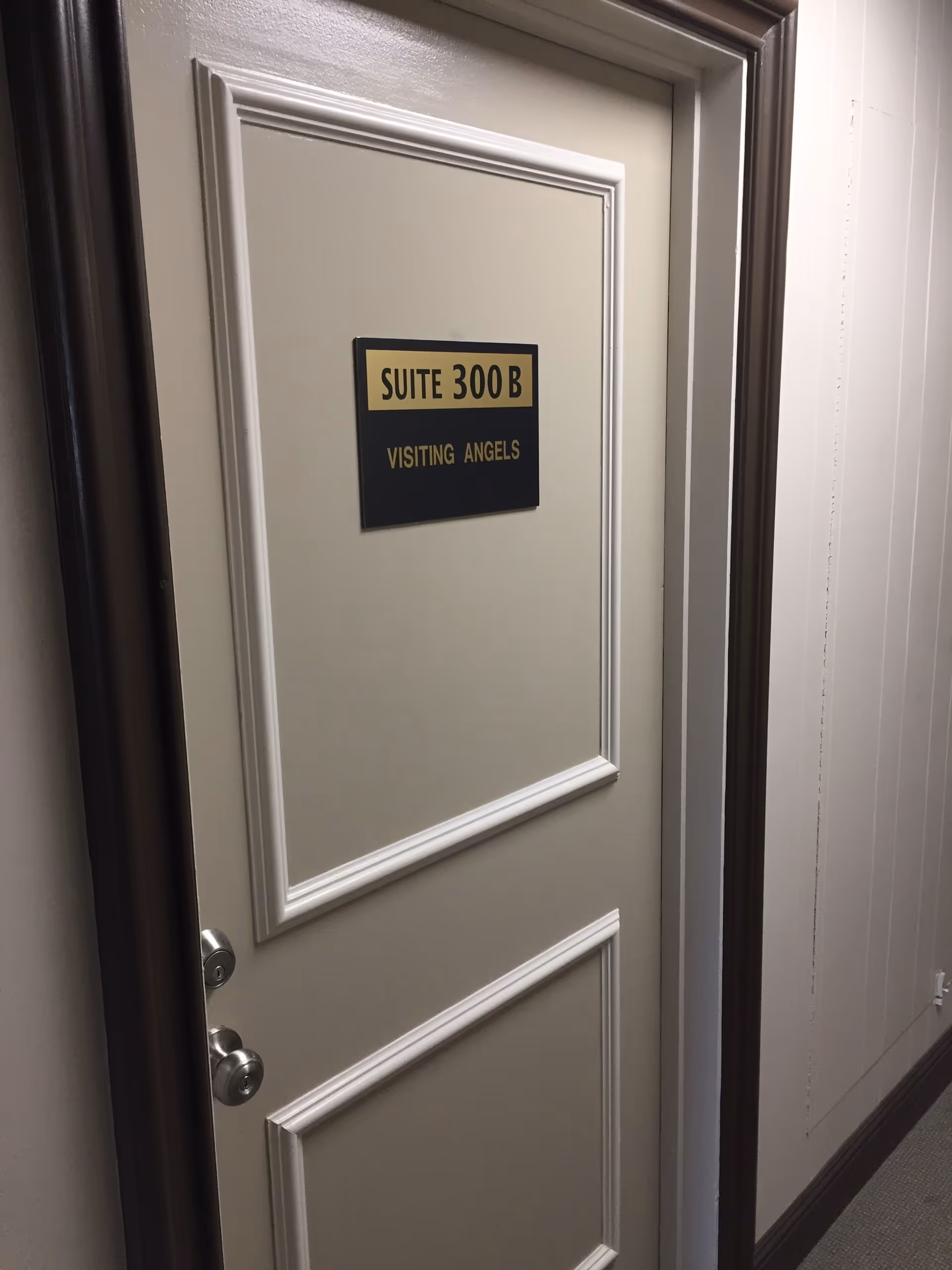 Interior hallway door with Suite 300 B and Visiting Angels sign.