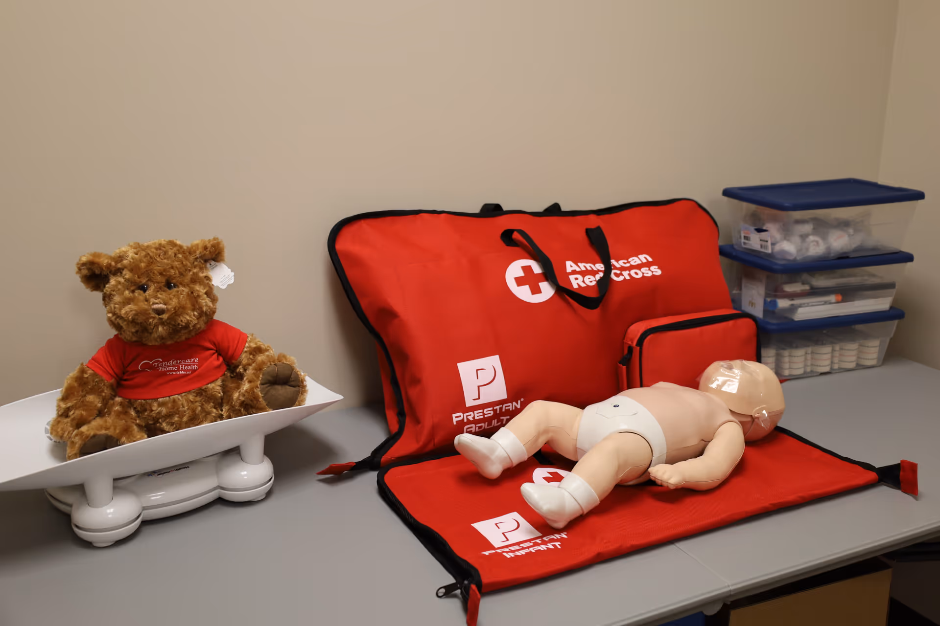 Teddy bear and CPR manikin with first aid kit on a clinic counter