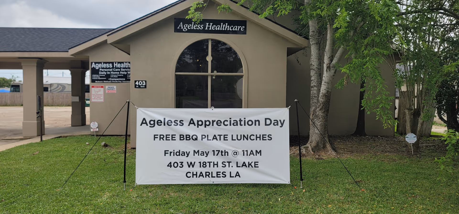 Front view of Ageless Healthcare building with a large event banner on the lawn.