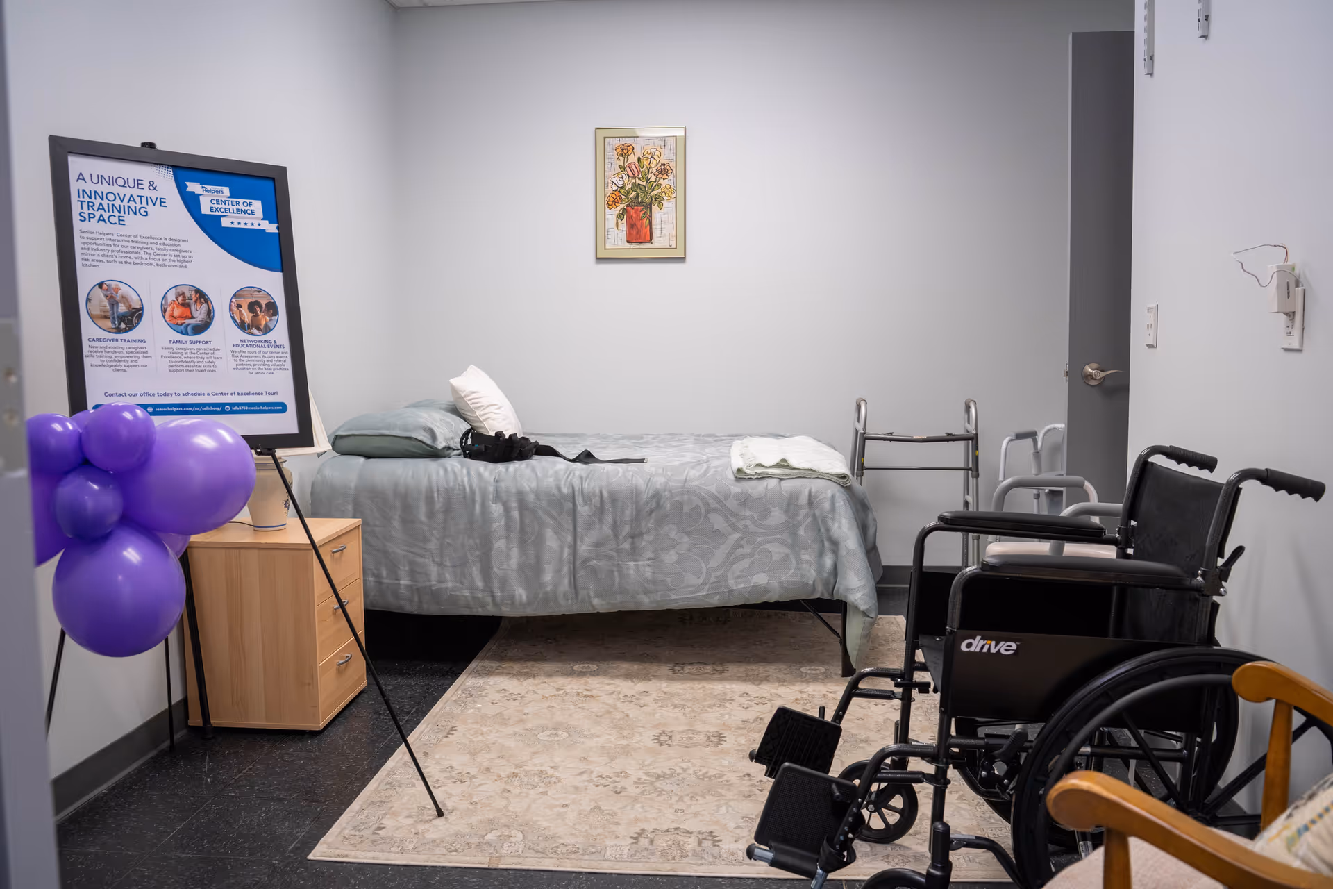 Bedroom in a senior living facility with bed, wheelchair, walker, and purple balloons.