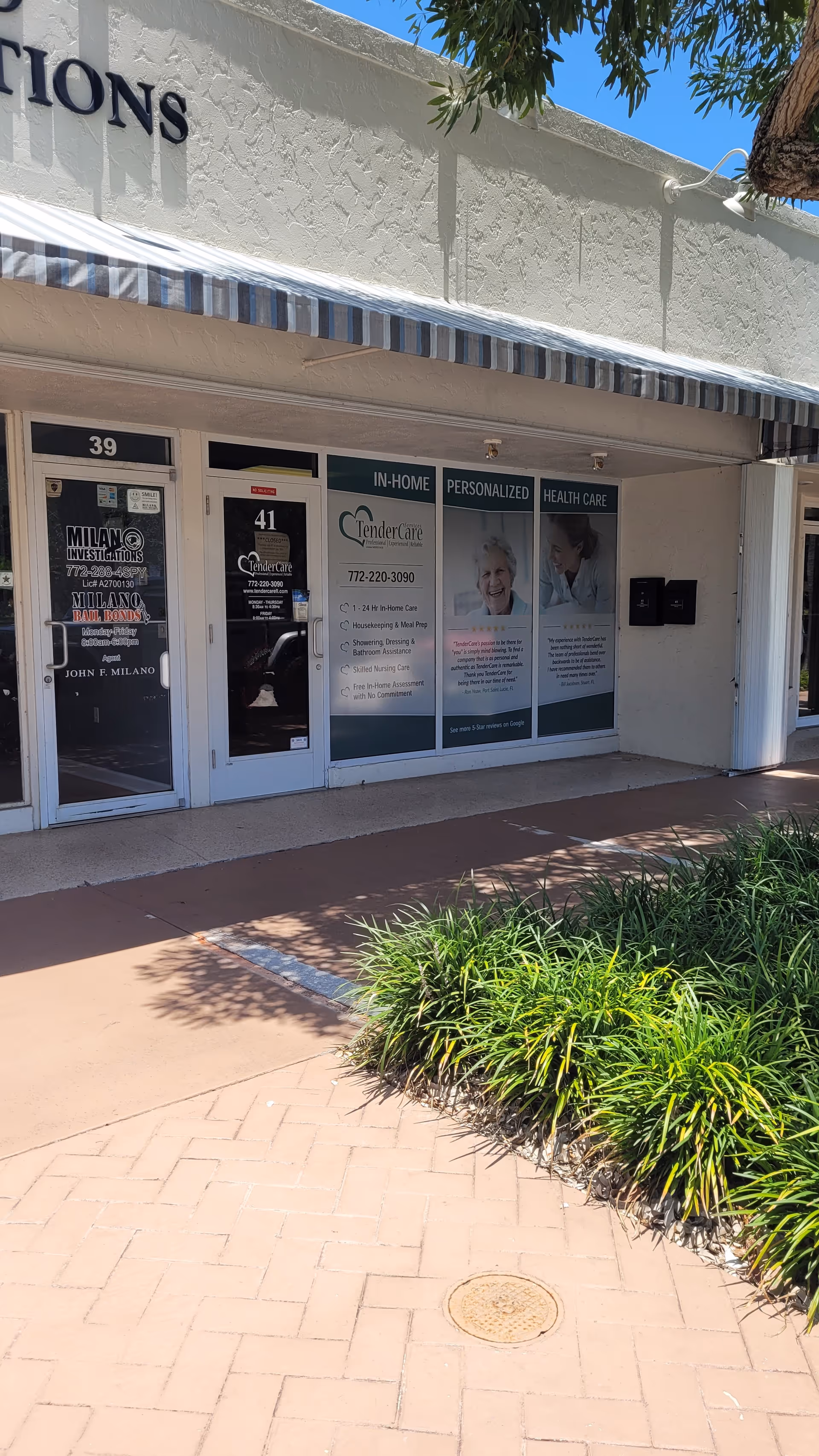 Storefront of TenderCare Services with posters and doors along a walkway.