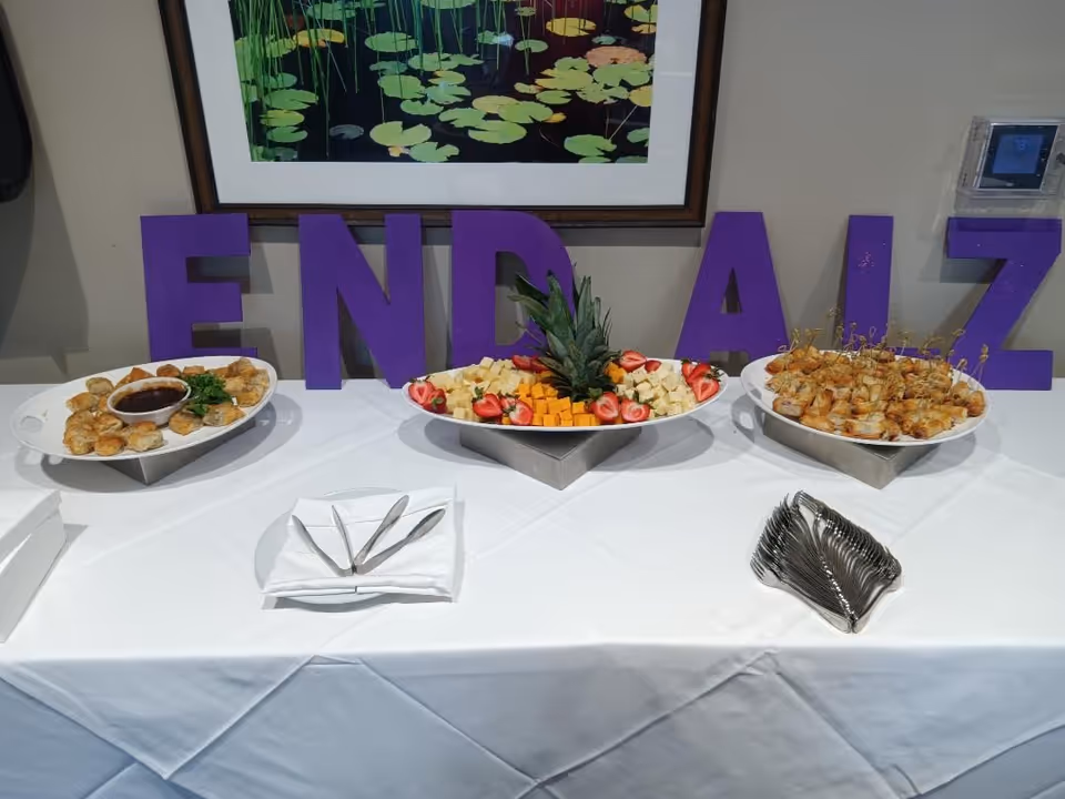 Buffet-style food spread on a white tablecloth dining room table in a senior home.