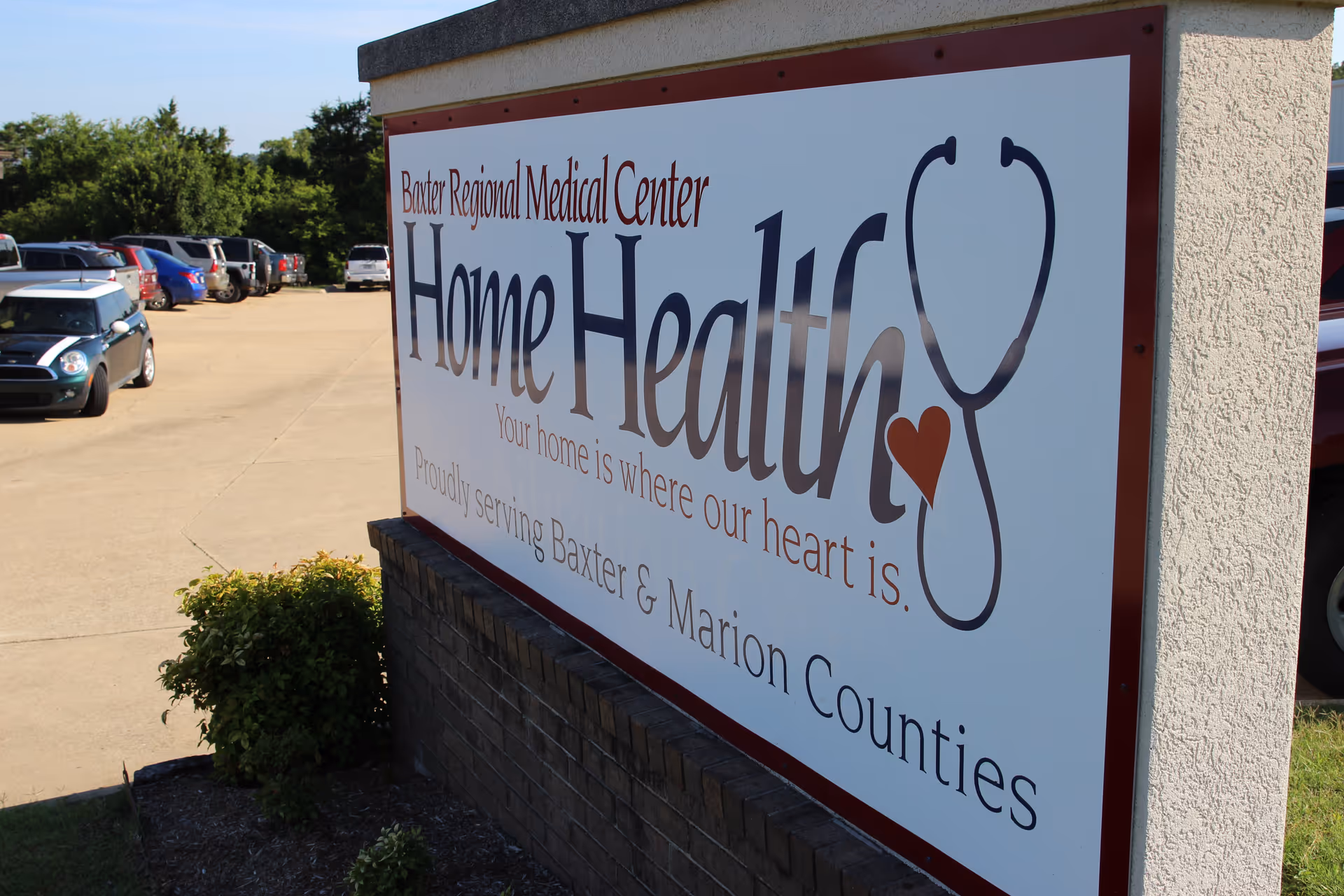 Large outdoor sign reads Home Health Baxter Regional Medical Center near a parking lot.