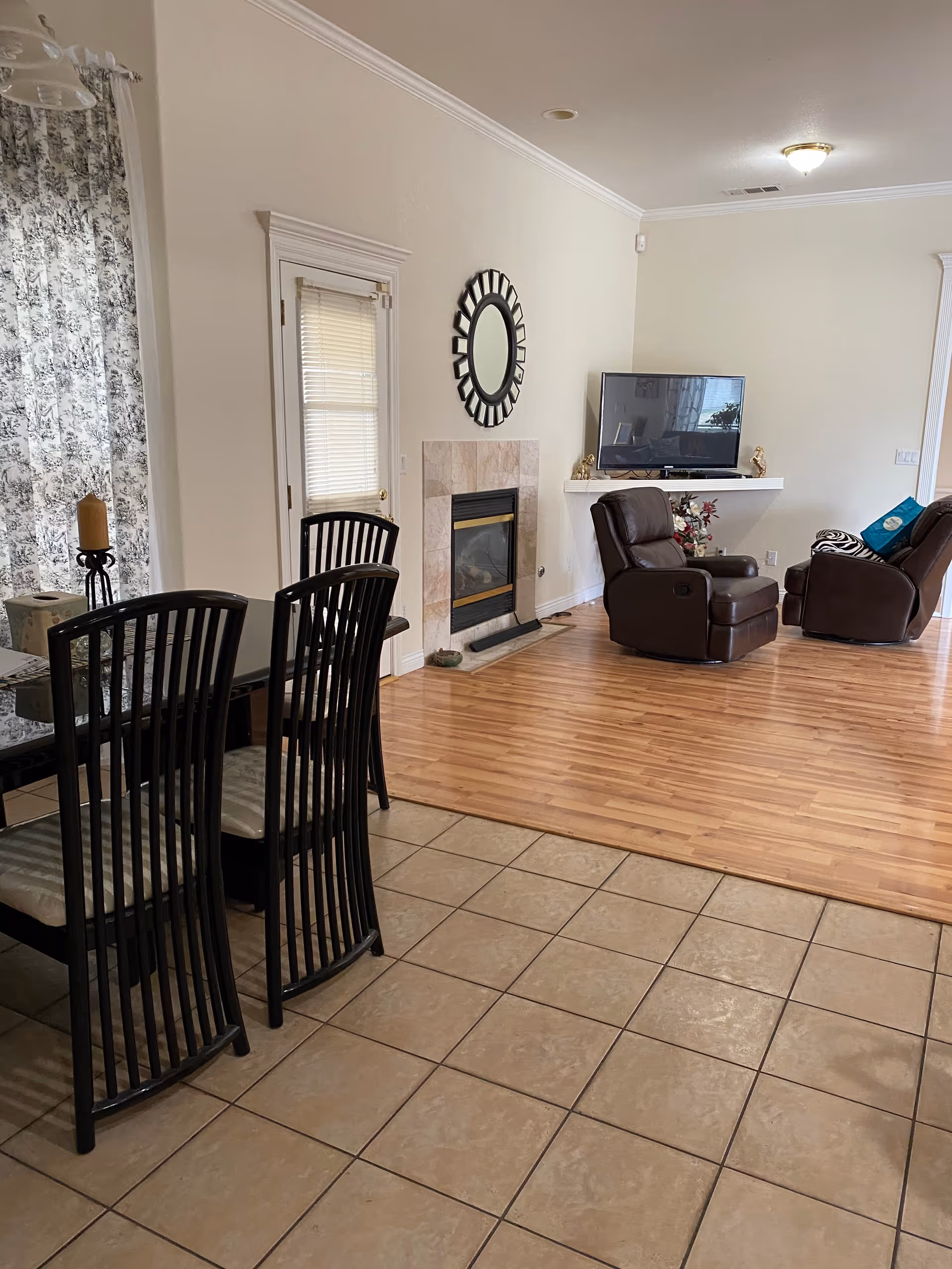 Living room in a senior care home with fireplace, TV, and brown recliners.