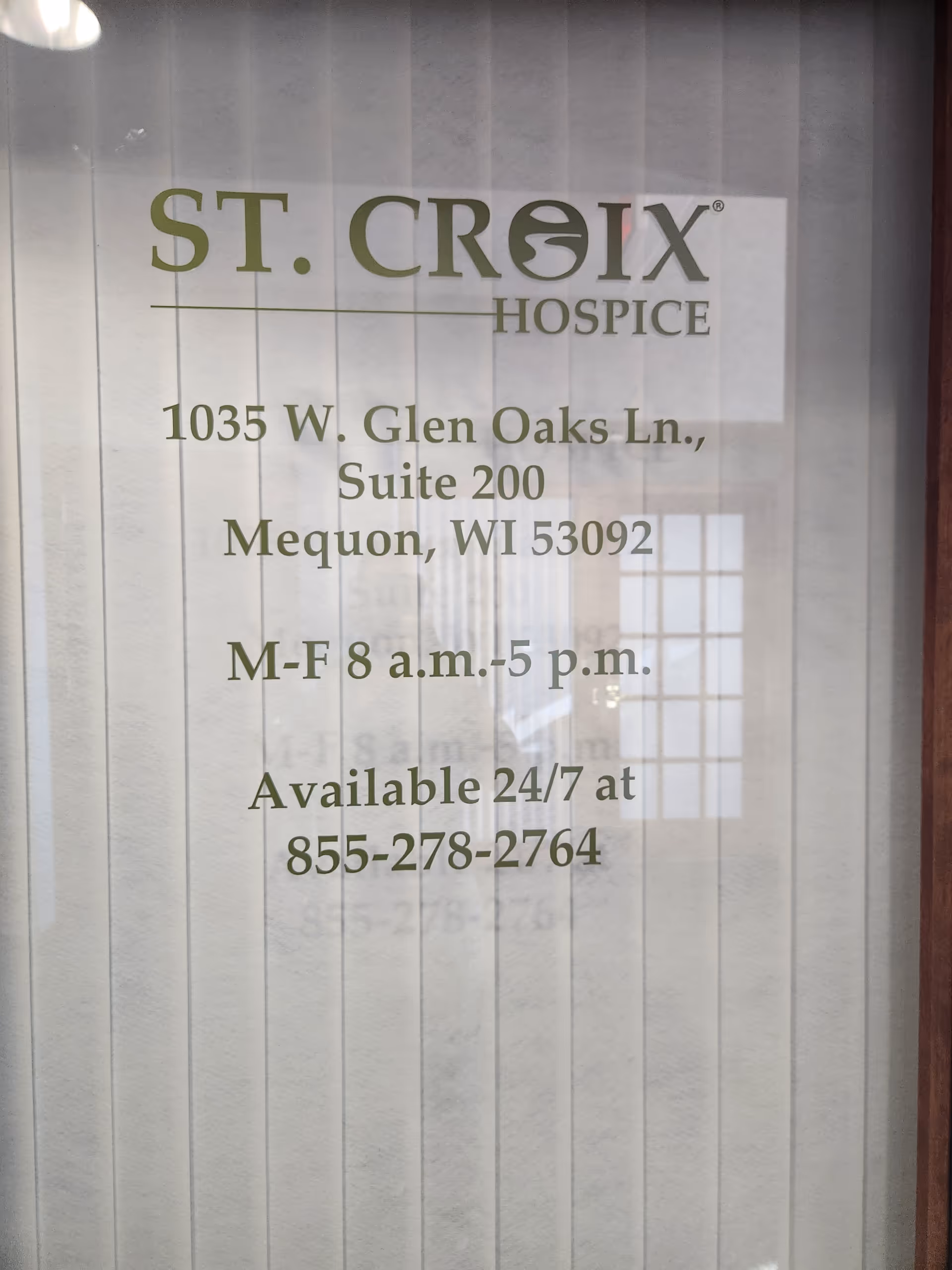 St. Croix Hospice window sign displaying address, hours, and phone number.