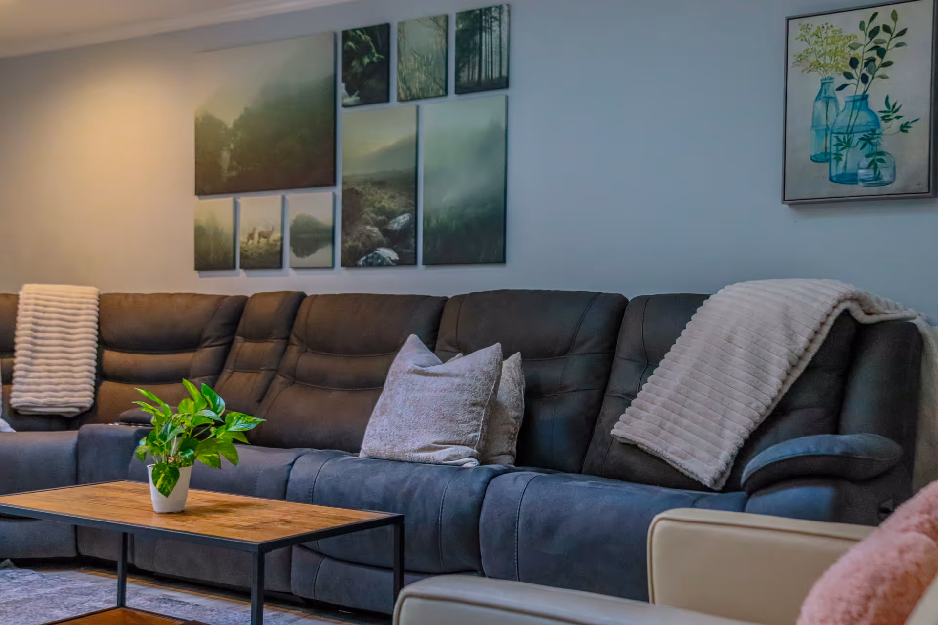 Cozy living room with a sectional sofa, blankets, wall art, and a coffee table.