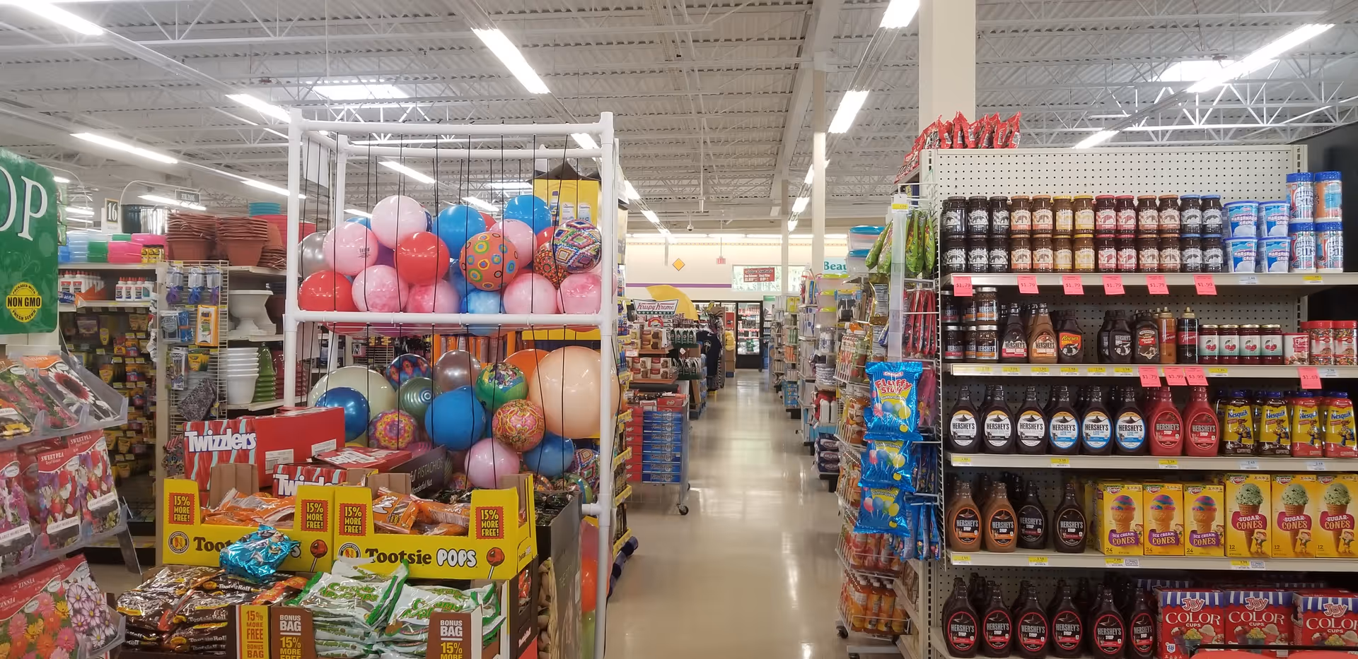 A Discount Drug Mart store interior with aisles, shelves stocked with snacks and beverages.