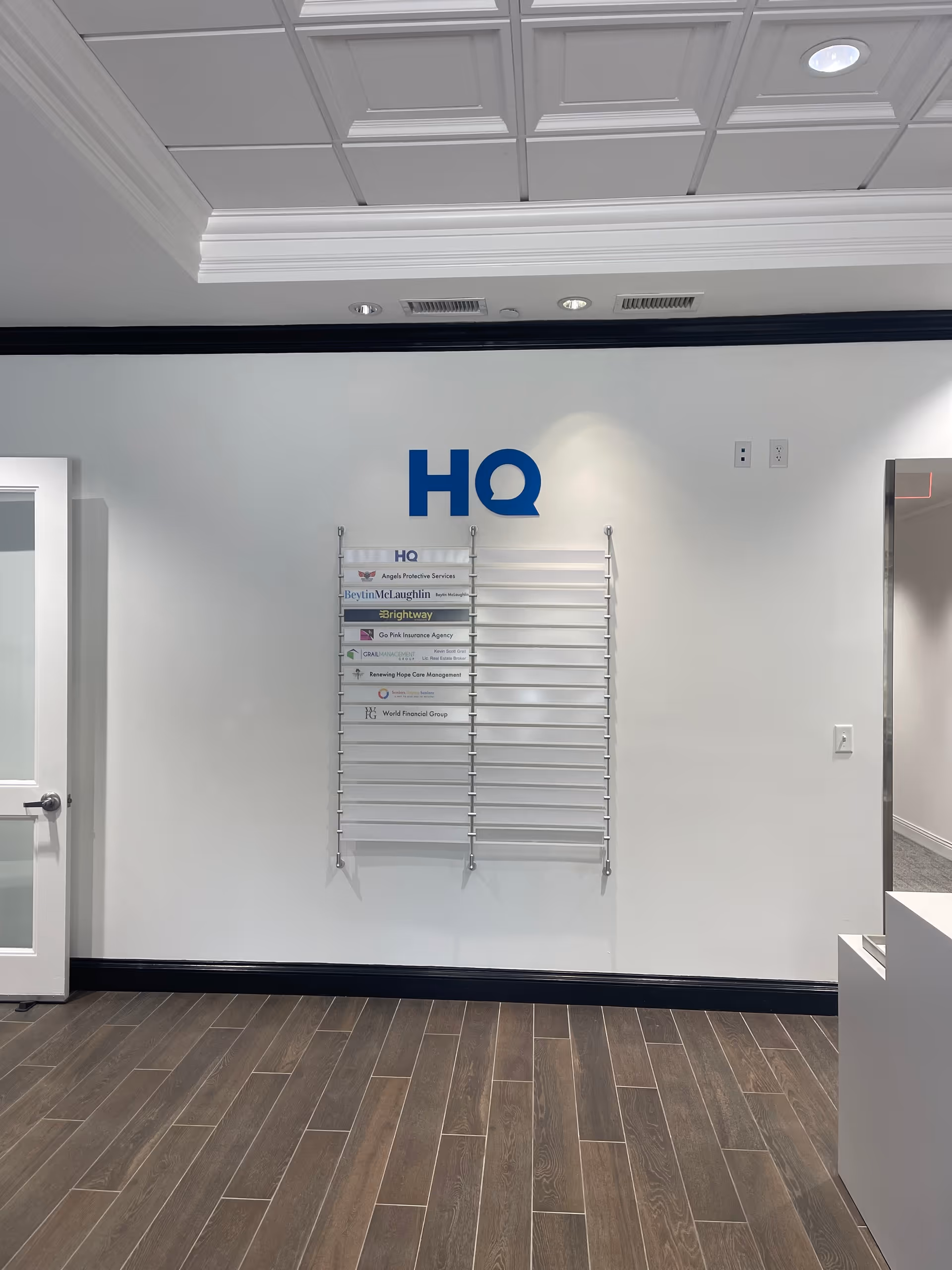 Interior lobby area with a blue HQ sign and a wall-mounted sign rack.