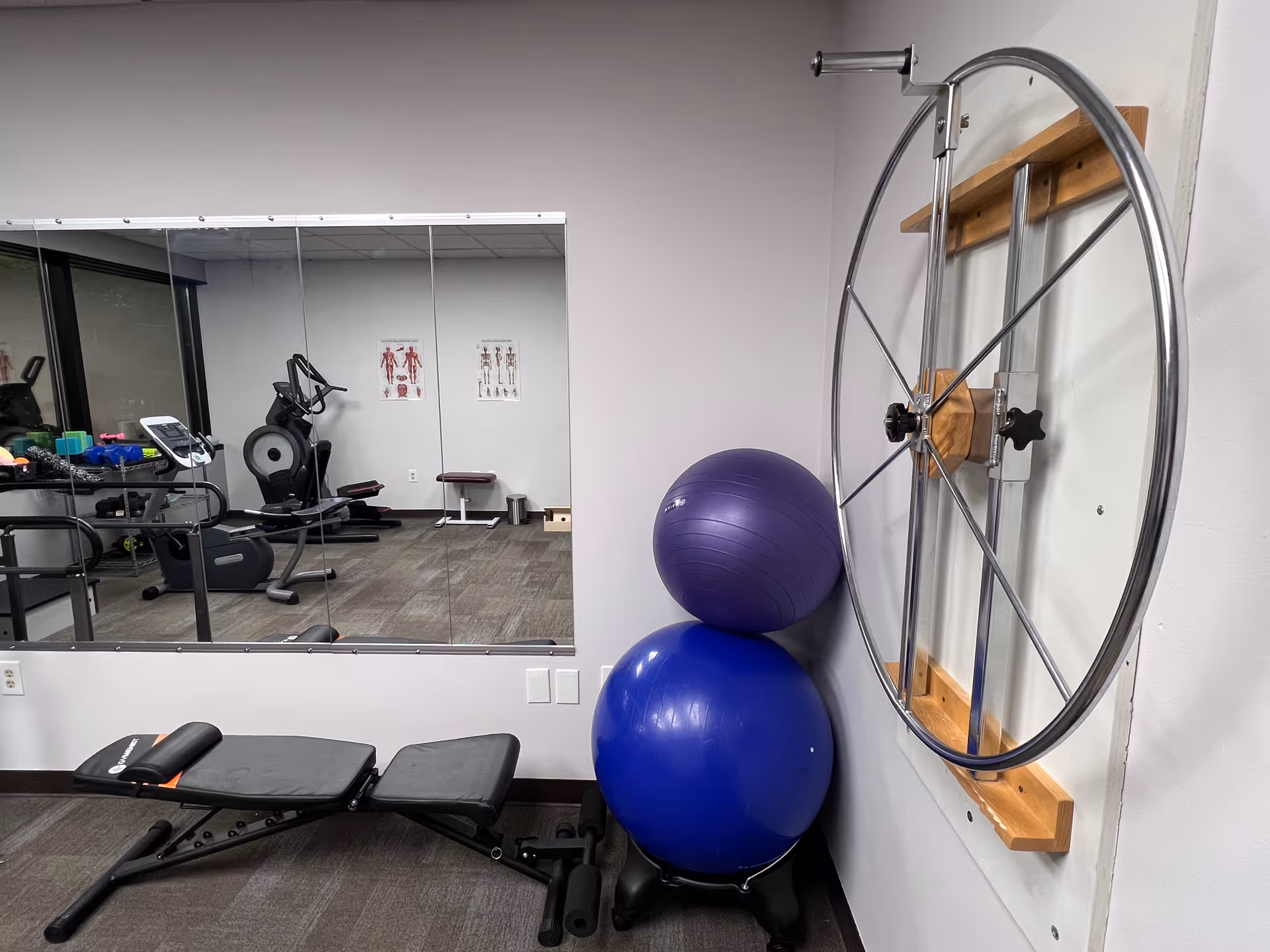 Interior senior fitness room with mirrored wall, exercise equipment, and stacked stability balls.