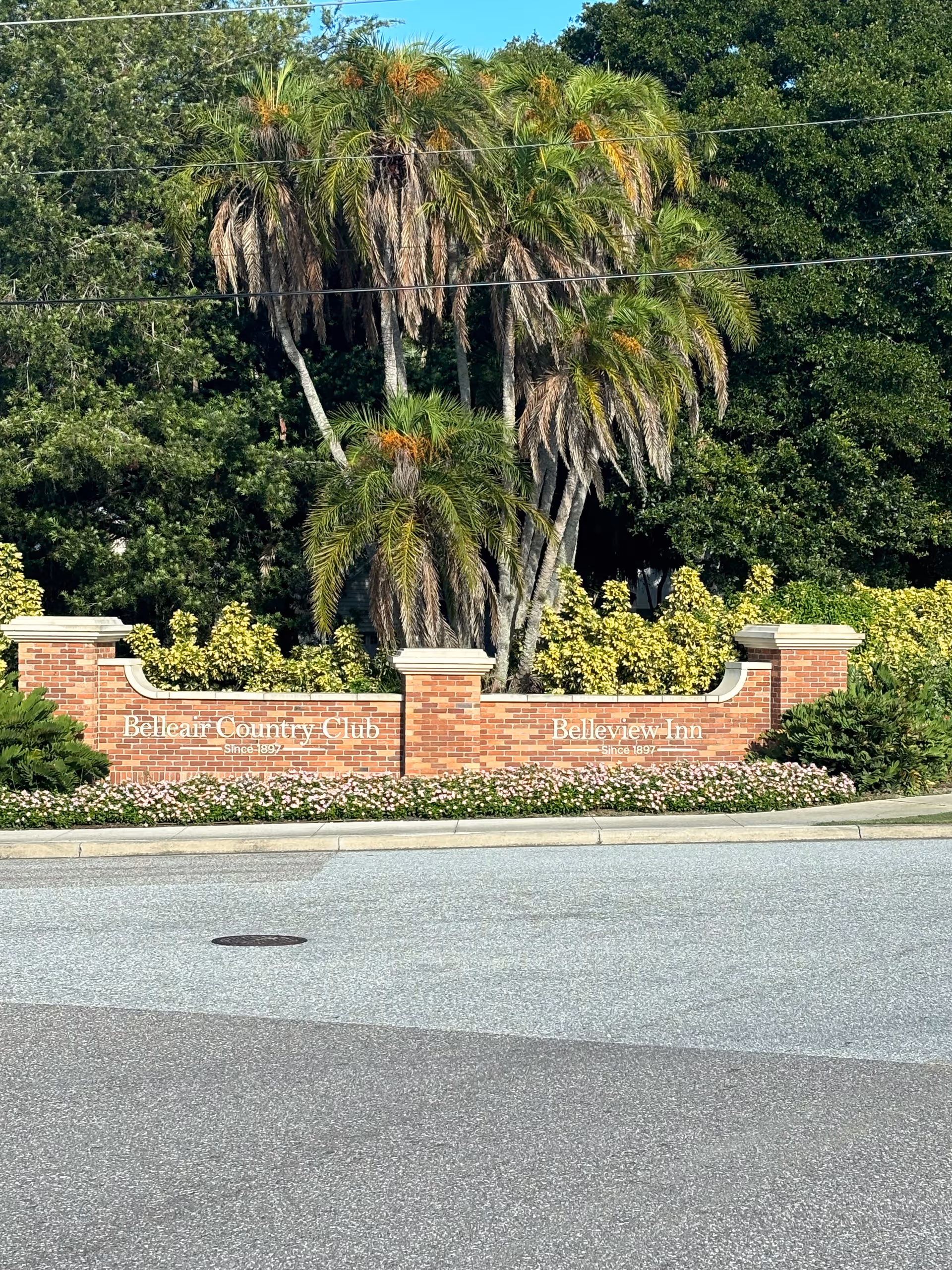 Brick entrance sign with Belleair Country Club and Belleview Inn surrounded by palm trees