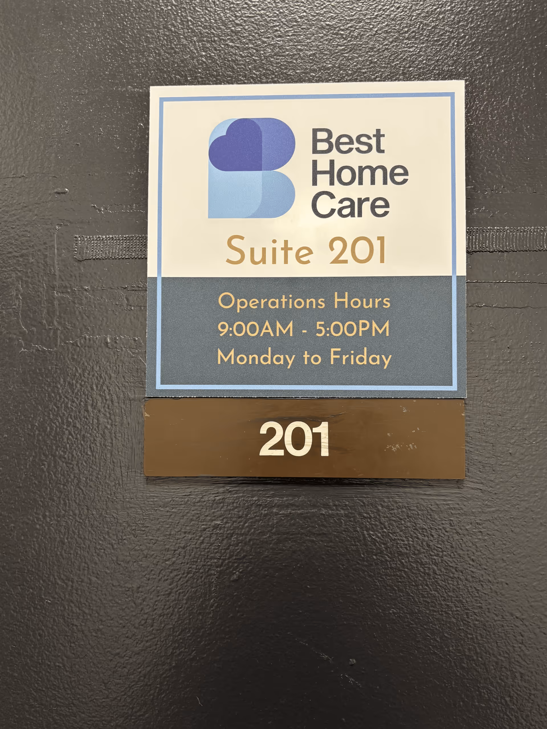 Wall sign for Best Home Care Suite 201 with hours.