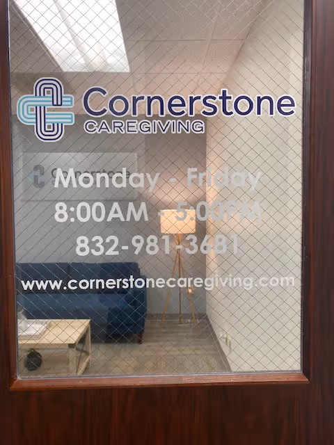 Glass entry door shows Cornerstone Caregiving logo and a small lobby with seating inside.