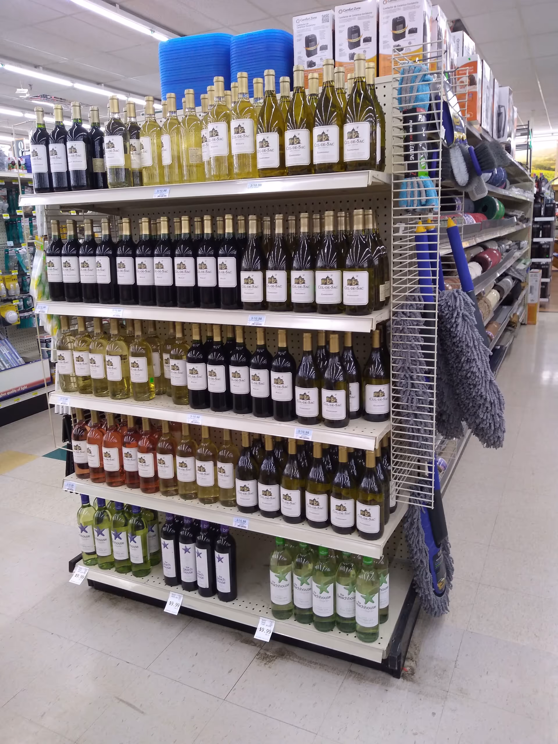 Aisle with wine bottles on metal shelves inside Discount Drug Mart.