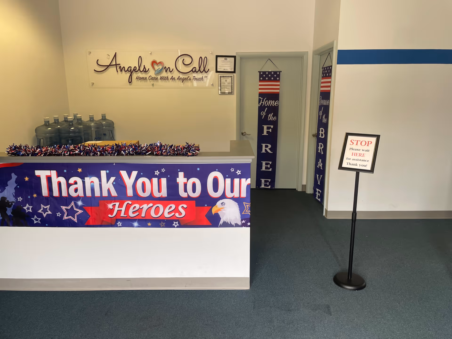 Reception desk with patriotic banner 'Thank You to Our Heroes' in Angels On Call lobby.
