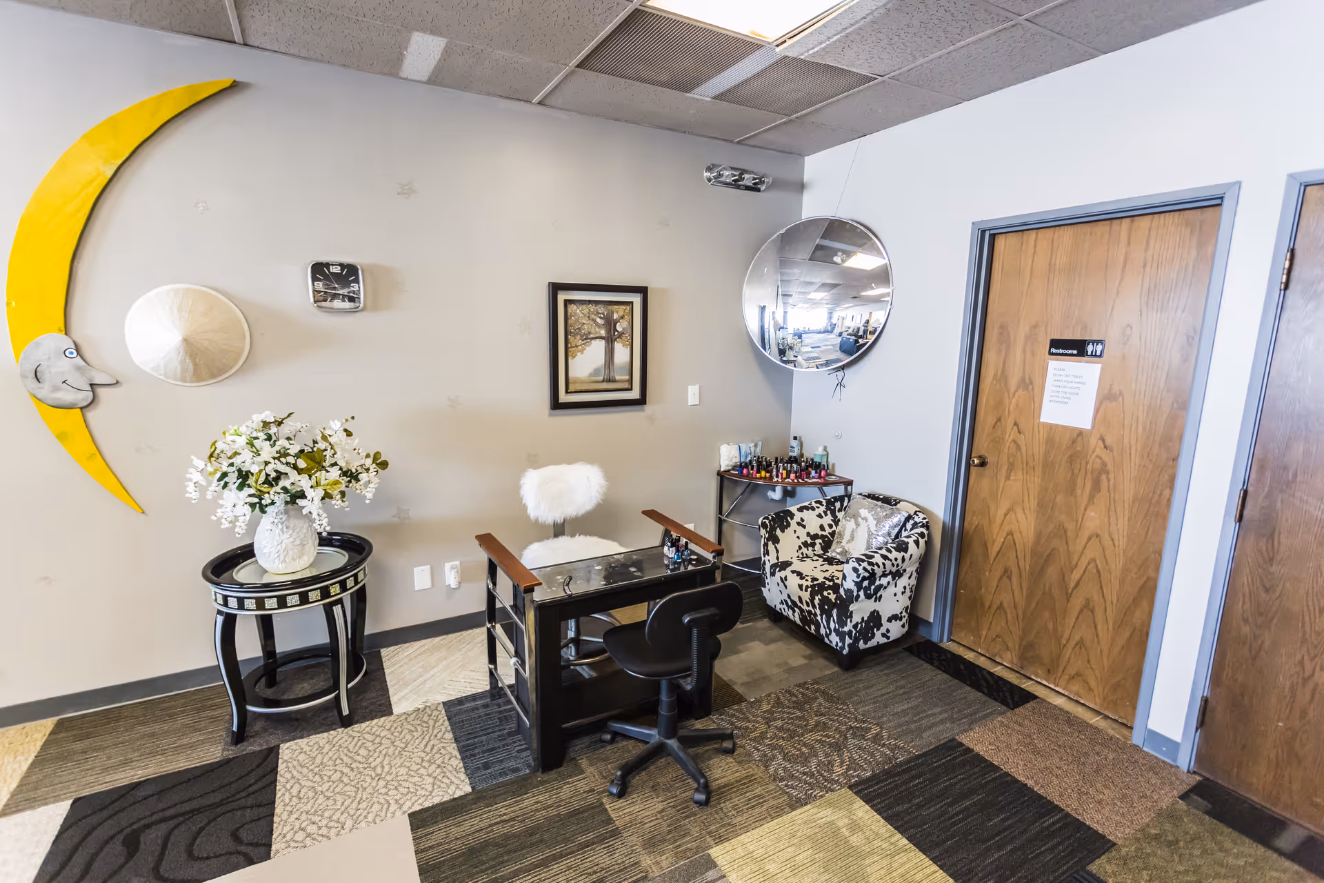 Salon-like reception area with manicure station, mirror, and floral decor.