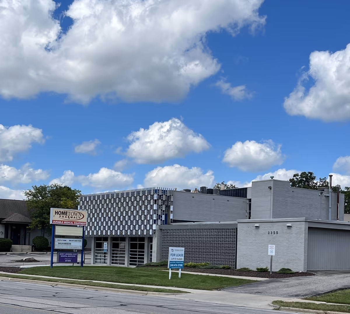 Exterior view of a low-rise building with a patterned facade and blue sky.