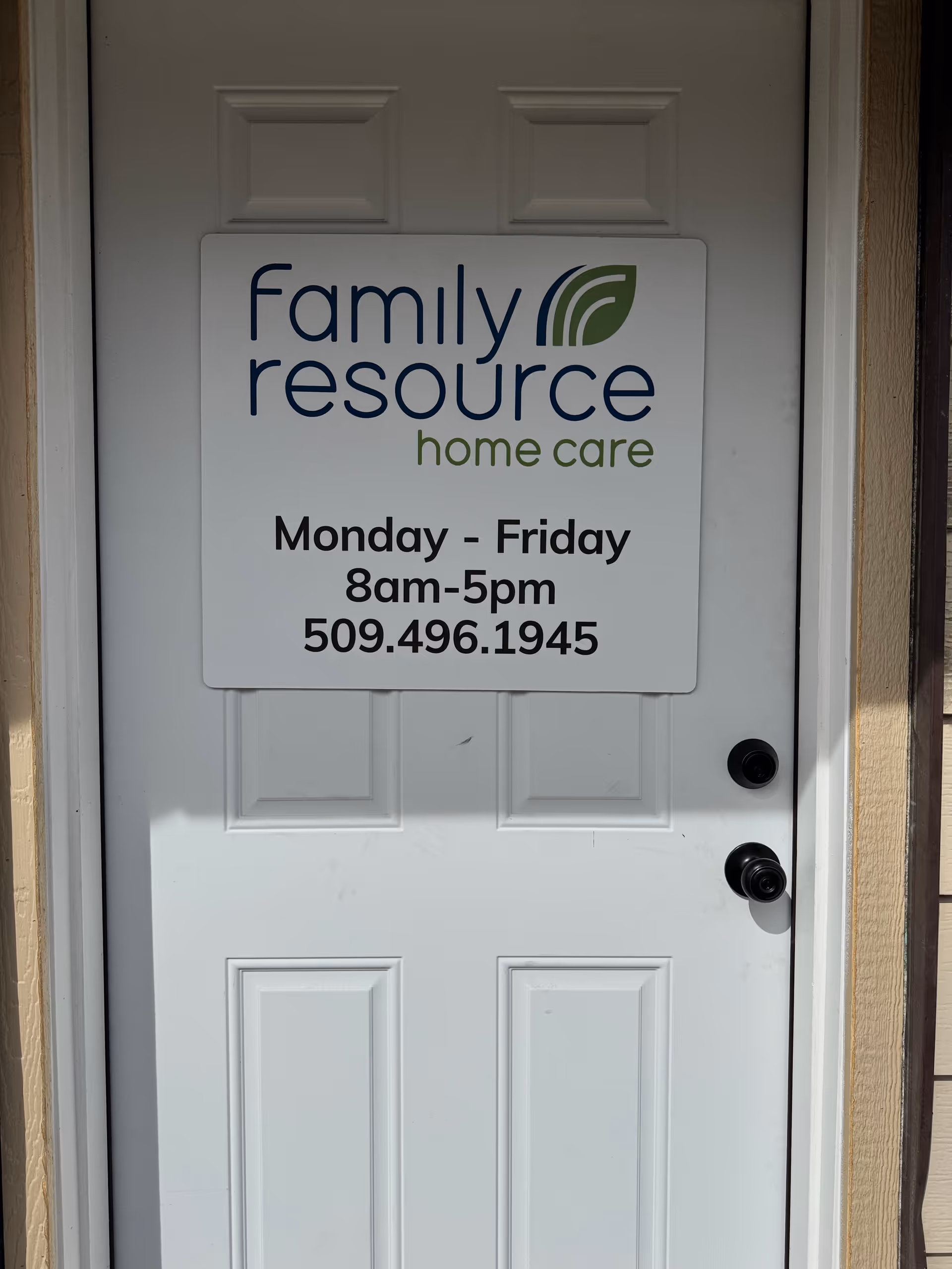 White exterior door with a sign for Family Resource Home Care and hours, Monday-Friday 8am-5pm, 509-496-1945.
