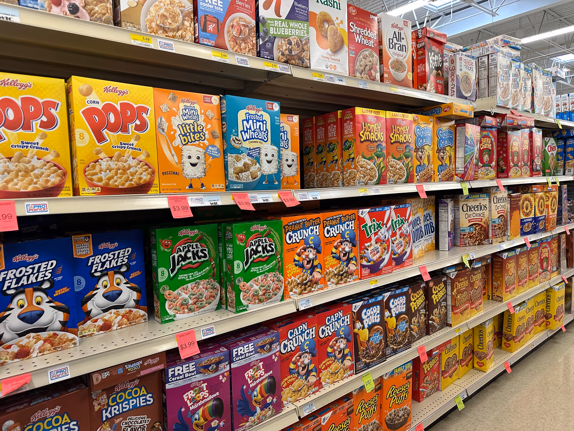 A grocery store aisle filled with colorful cereal boxes on shelves.