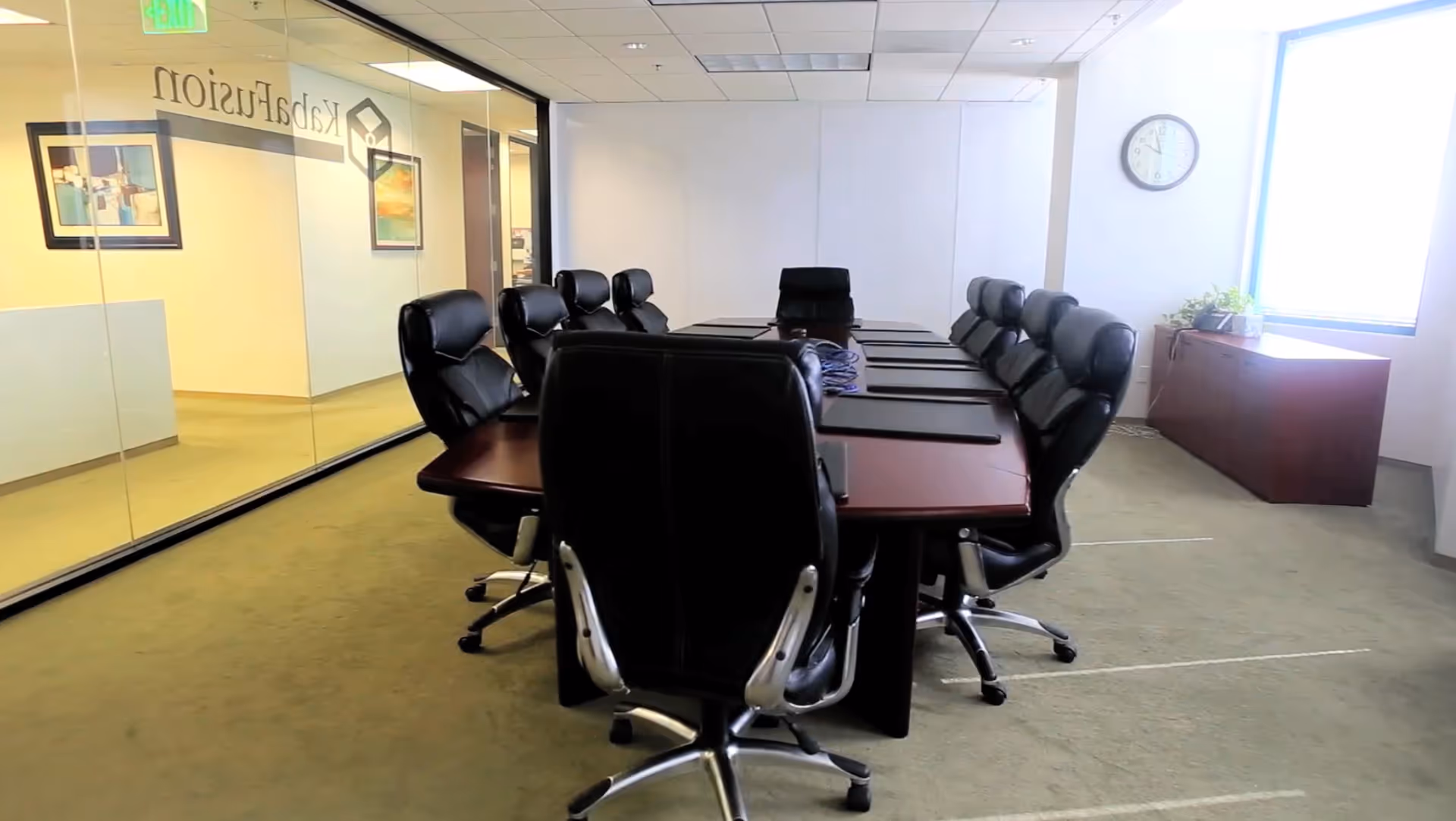 A conference room in a senior facility with a long table and black swivel chairs.