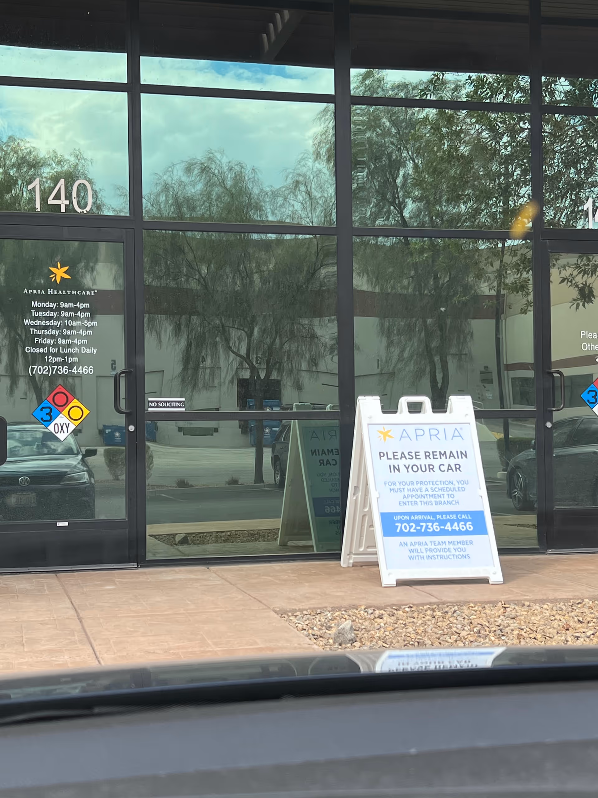 Front entrance of Apria Healthcare facility with glass doors and signage.