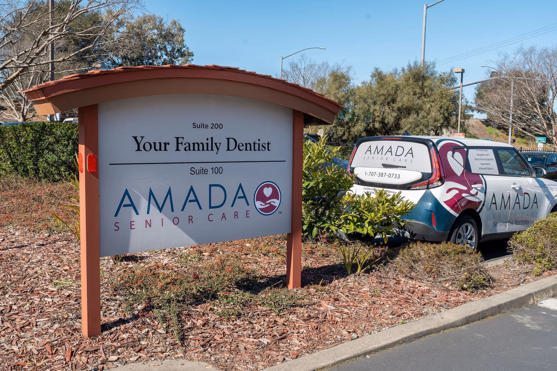 Outdoor scene with Amada Senior Care signage and a branded service vehicle.