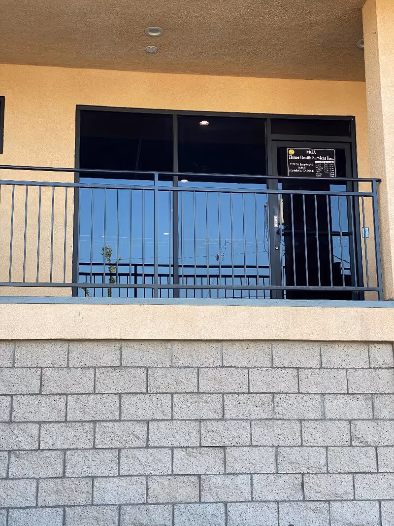 Exterior entrance of M.G.A. Home Health Services with glass doors and railing.