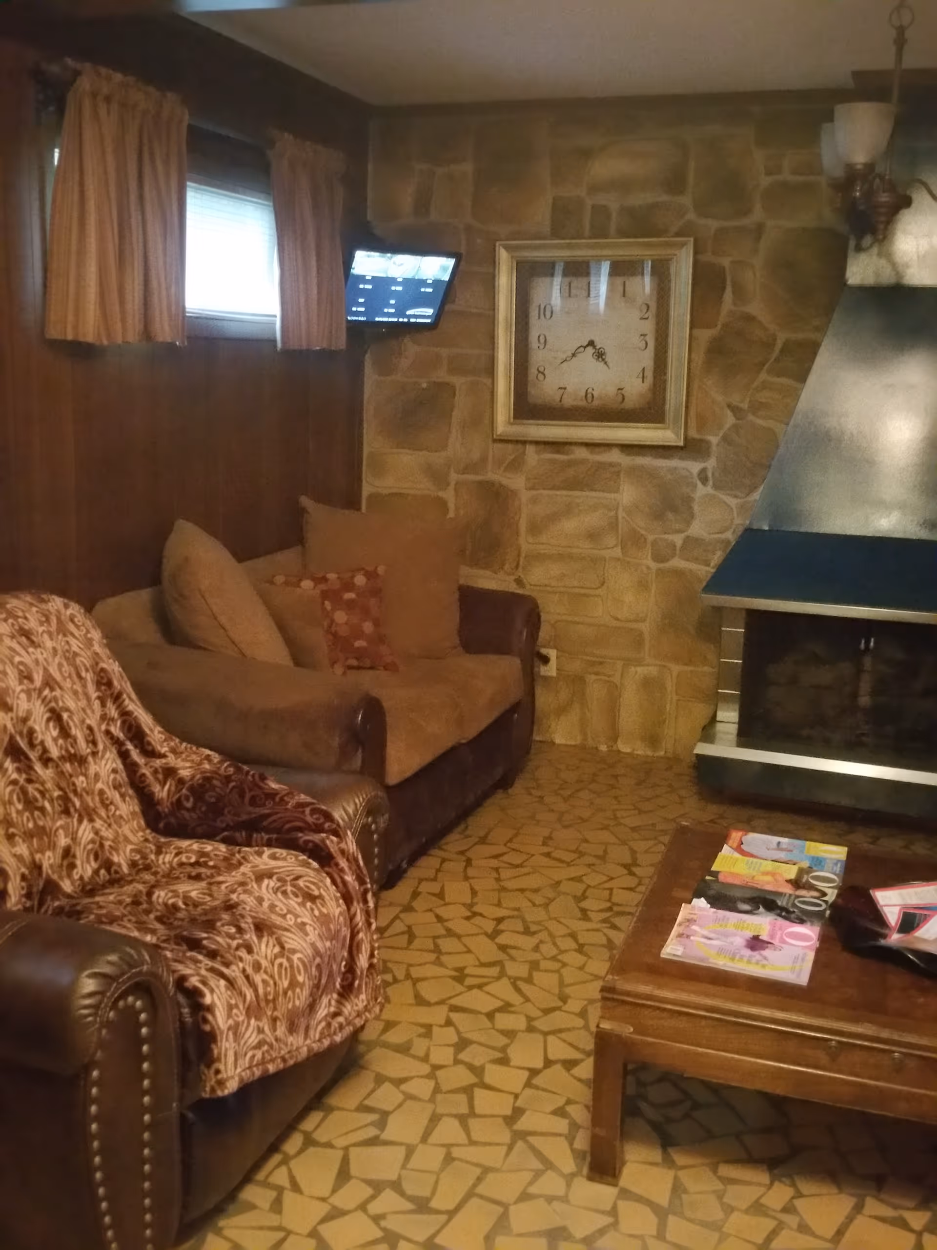Cozy living room with a stone fireplace, leather sofa, and a coffee table.