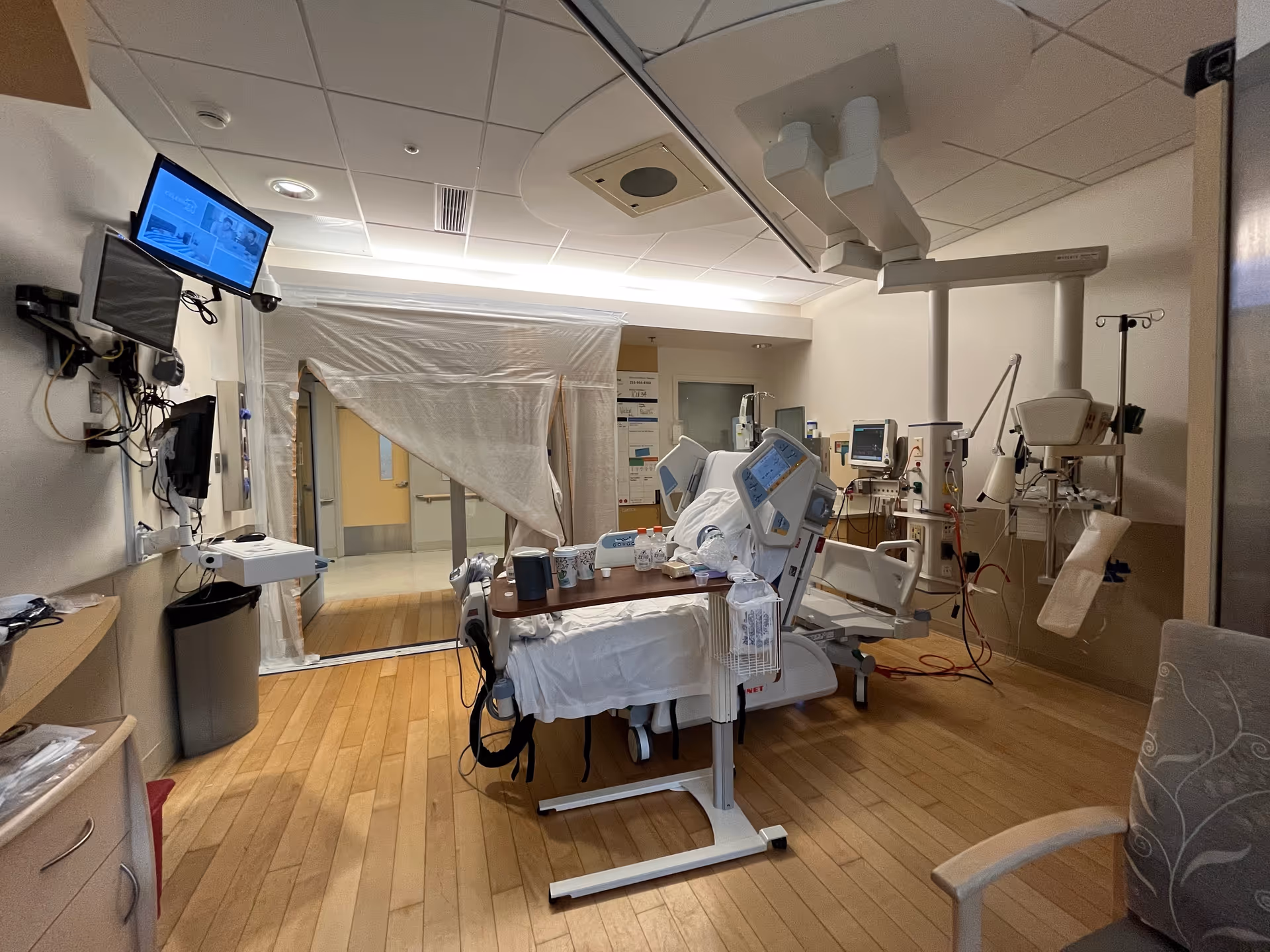 Hospital operating room with advanced medical equipment and a patient bed in a bright, sterile interior.