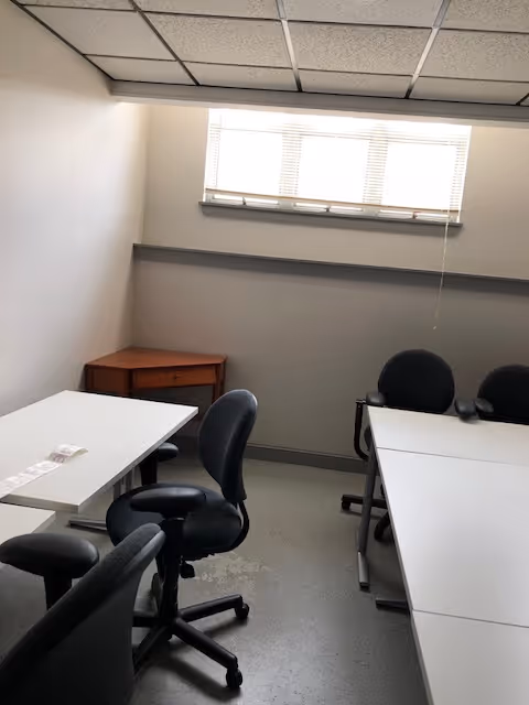 Small interior meeting room in a senior living facility with desks and chairs.