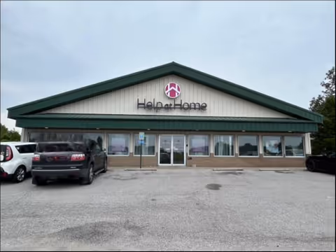 Front view of Help at Home senior living facility with cars in the parking lot.