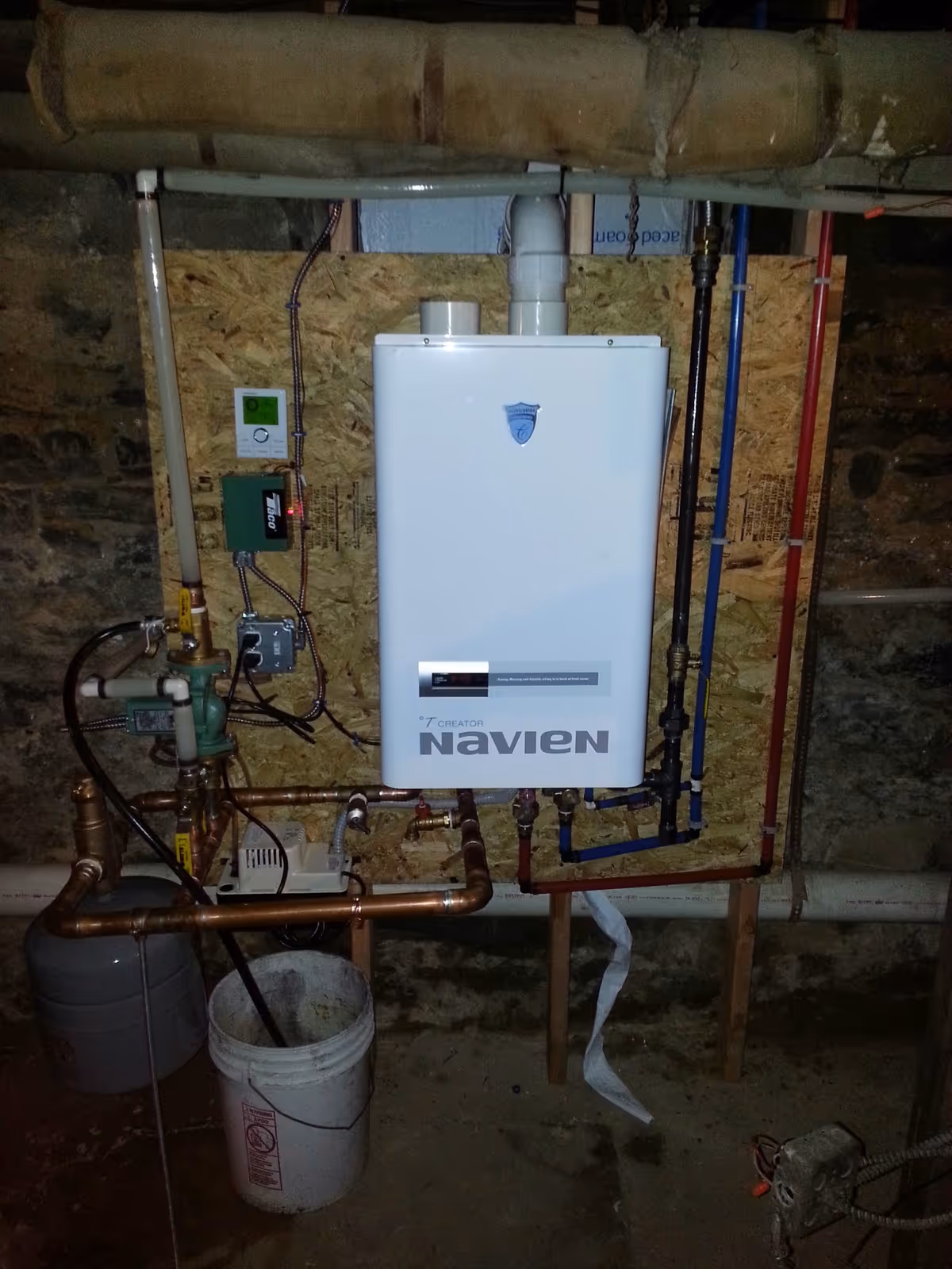 Basement utility room features a Navien boiler and exposed copper piping.