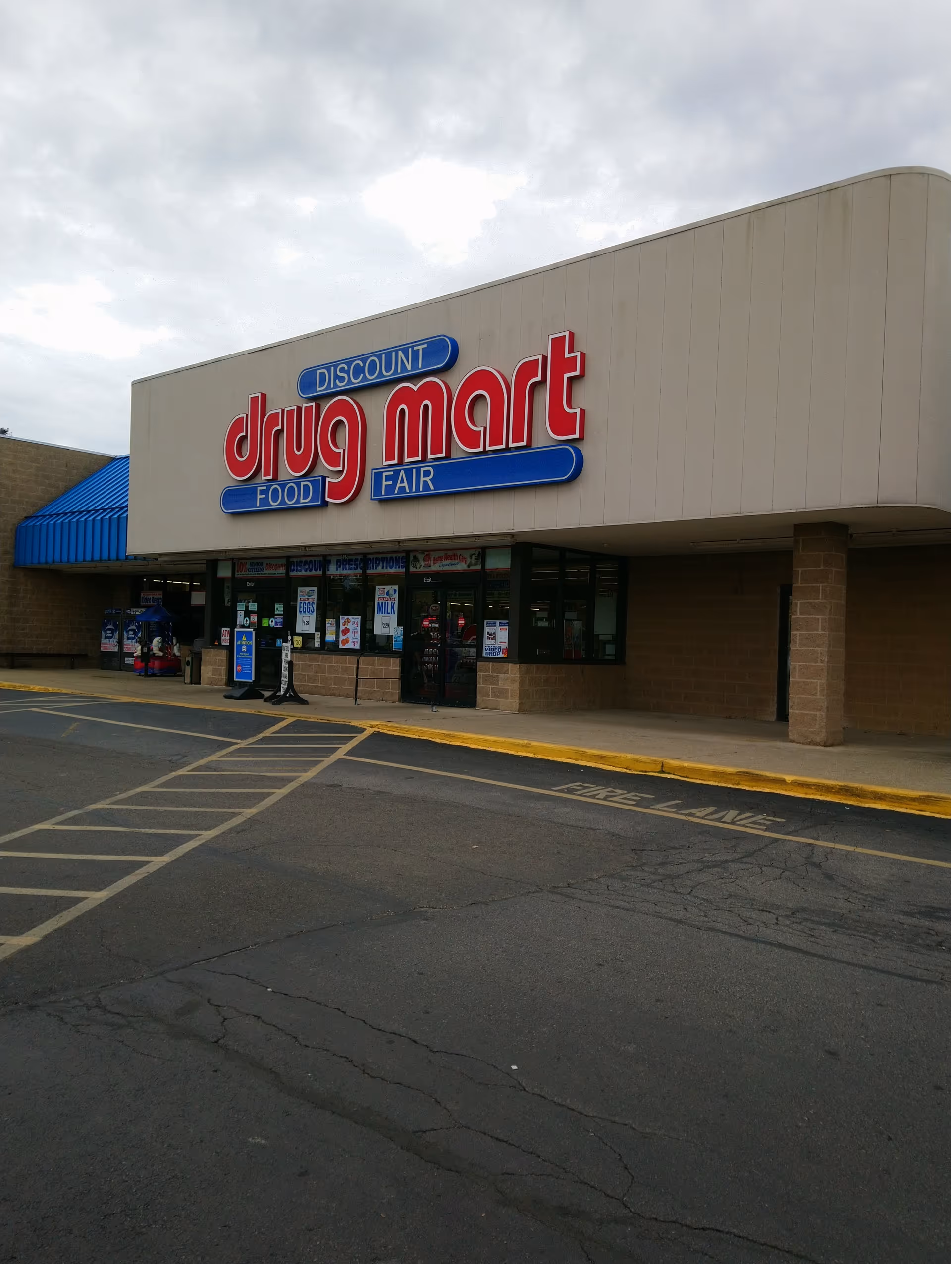 Front view of a Discount Drug Mart storefront with large red and blue signage outside.