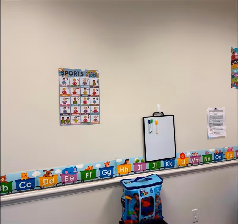 Interior wall with alphabet border, whiteboard, and a sports poster